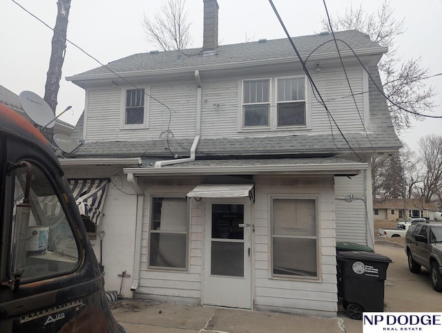 back of property with roof with shingles