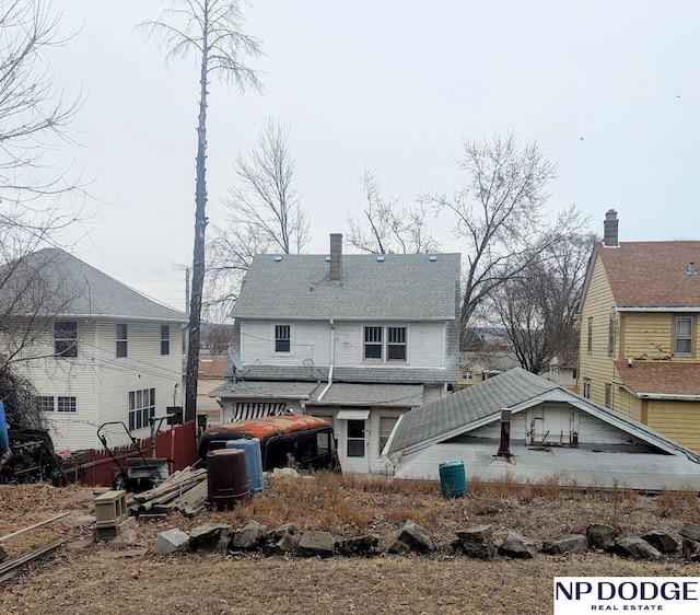 rear view of house featuring a chimney