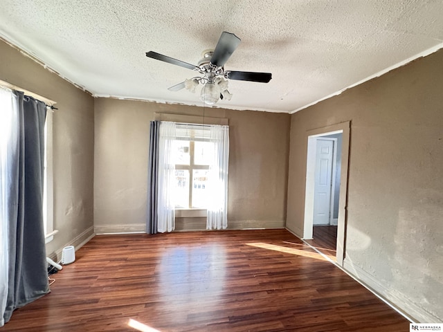 spare room featuring a ceiling fan, a textured ceiling, baseboards, and wood finished floors