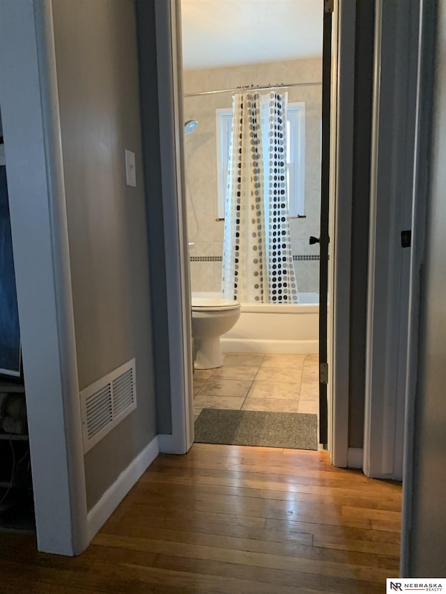 corridor with hardwood / wood-style flooring