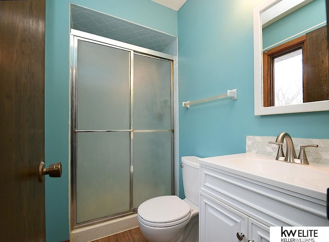 bathroom featuring walk in shower, vanity, and toilet