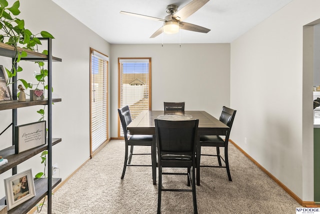 carpeted dining room with ceiling fan