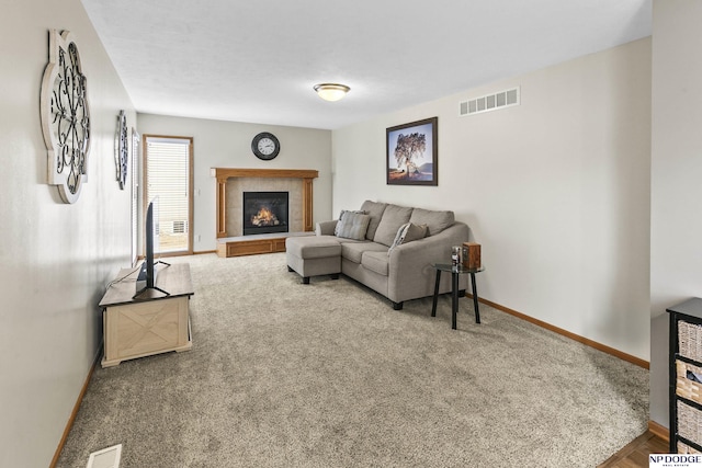 living room featuring a tile fireplace and carpet flooring