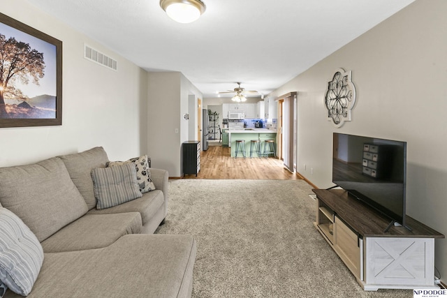 living room with light colored carpet and ceiling fan