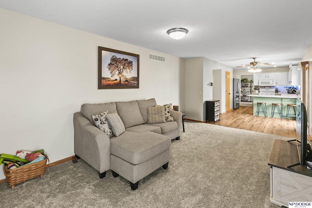 living room featuring light carpet and ceiling fan