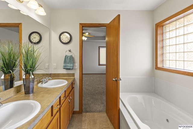 bathroom with tile patterned flooring, vanity, and a relaxing tiled tub