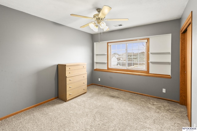 unfurnished bedroom with ceiling fan, light colored carpet, and a closet