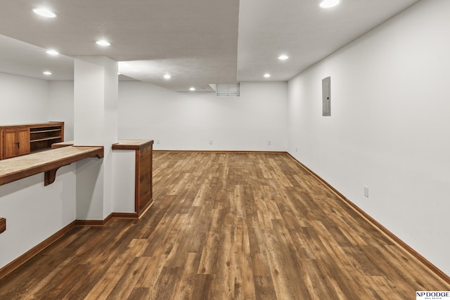 basement with electric panel and dark hardwood / wood-style floors