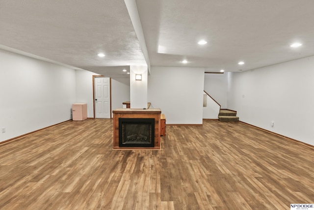 basement with hardwood / wood-style floors and a textured ceiling