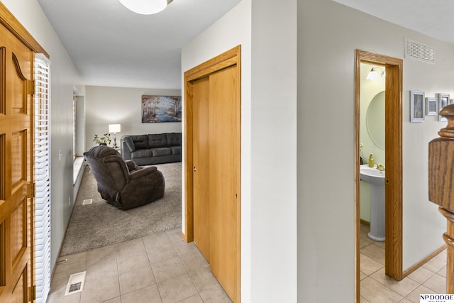 hallway with light tile patterned flooring and sink