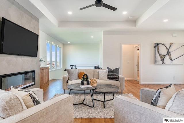 living room featuring a raised ceiling and light wood-type flooring