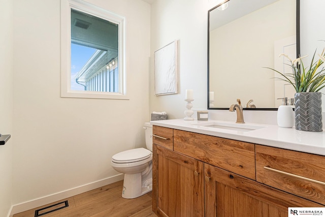 bathroom with hardwood / wood-style flooring, vanity, and toilet