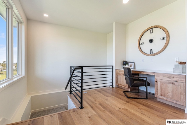 office area with built in desk and light hardwood / wood-style flooring