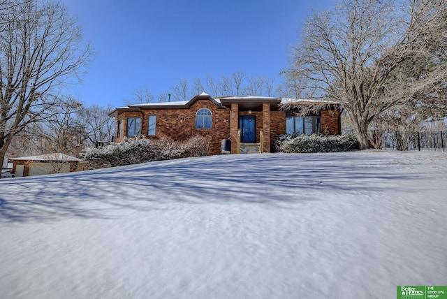 view of front facade featuring brick siding and fence