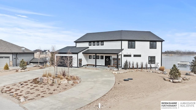 view of front of house featuring a garage and a water view