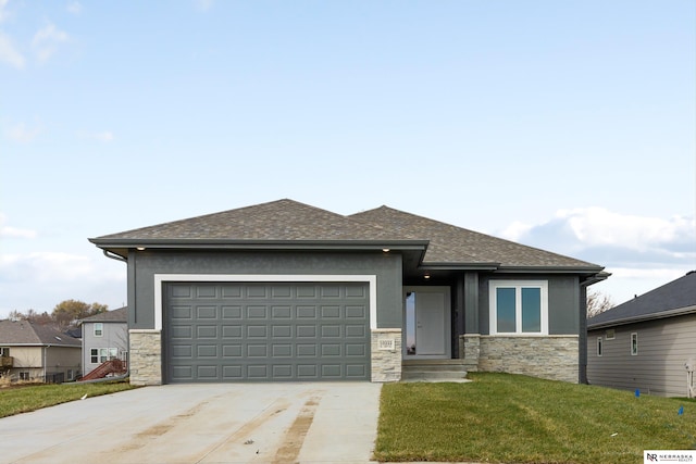 prairie-style house featuring an attached garage, driveway, stone siding, stucco siding, and a front lawn