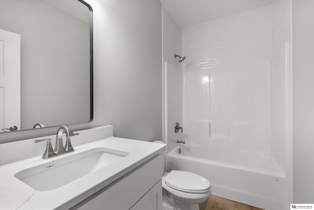 bathroom with toilet, shower / bathing tub combination, wood finished floors, and vanity