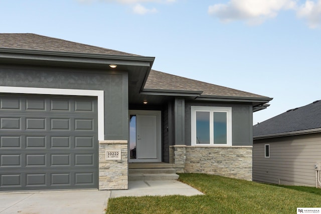 view of front of property featuring stone siding, a shingled roof, a front lawn, and an attached garage