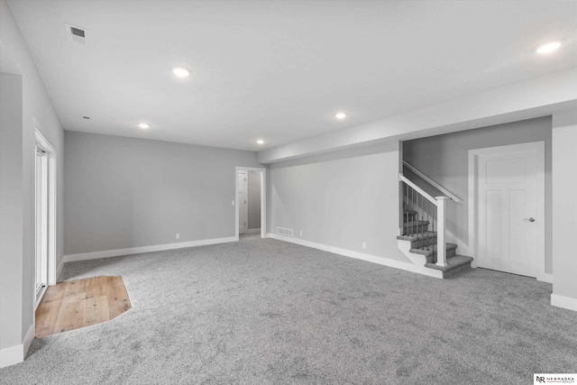 basement featuring carpet floors, stairs, visible vents, and recessed lighting