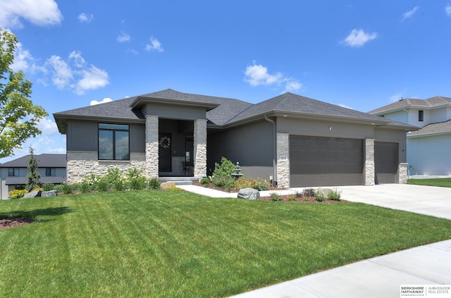 prairie-style home featuring a garage and a front lawn