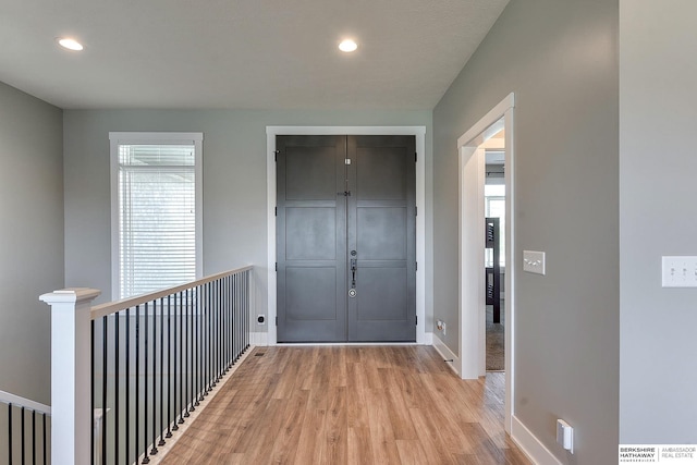 hallway featuring a healthy amount of sunlight and light hardwood / wood-style floors