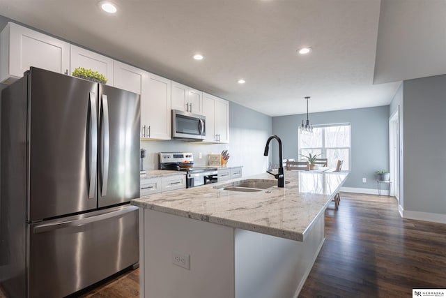 kitchen with white cabinetry, sink, a kitchen island with sink, stainless steel appliances, and light stone countertops