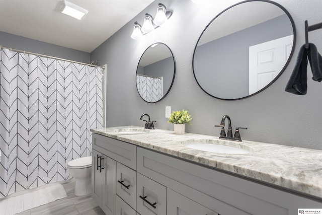 bathroom with vanity, curtained shower, and toilet