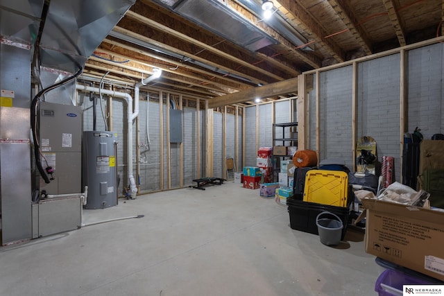 basement featuring heating unit, electric panel, and electric water heater