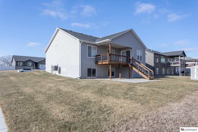 rear view of house featuring a deck and a lawn