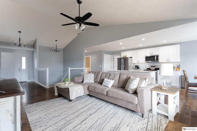 living room featuring ceiling fan with notable chandelier, lofted ceiling, and hardwood / wood-style floors