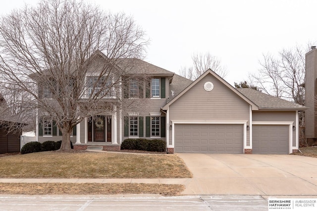 colonial inspired home with a garage and a front lawn