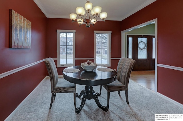 carpeted dining room featuring an inviting chandelier and ornamental molding