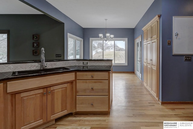 kitchen with decorative light fixtures, a chandelier, sink, and backsplash