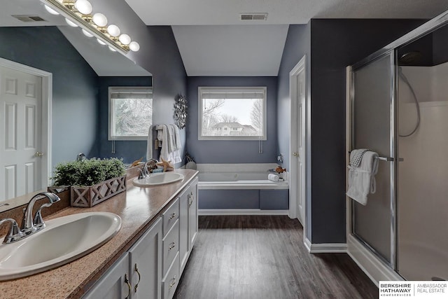 bathroom with vaulted ceiling, vanity, plus walk in shower, and hardwood / wood-style floors