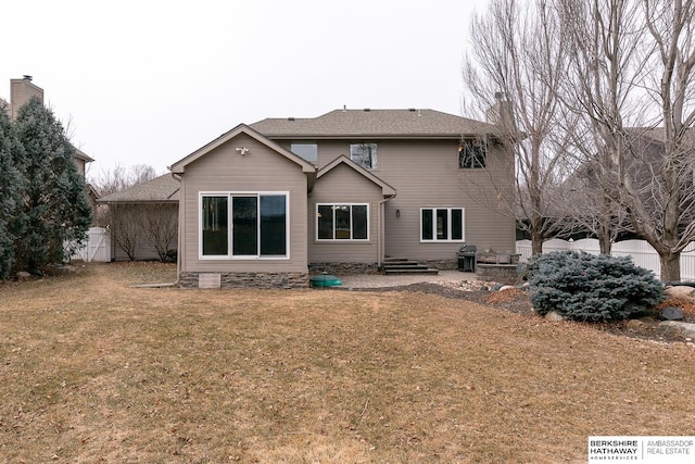 rear view of property featuring a lawn