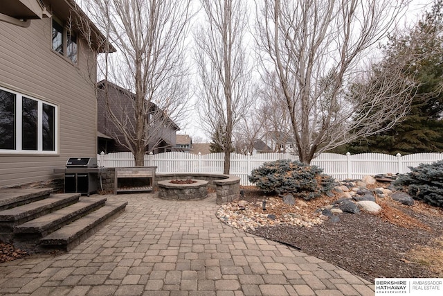 view of patio with an outdoor fire pit and a grill