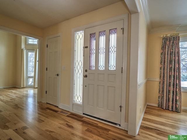 entryway with a healthy amount of sunlight, light wood-style flooring, and baseboards