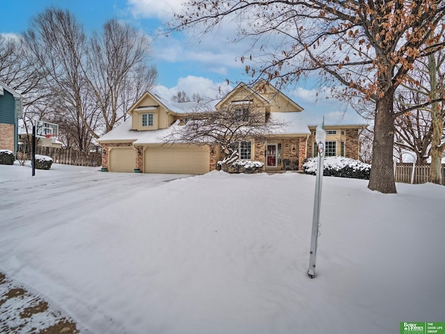 view of front of house with a garage, fence, and brick siding