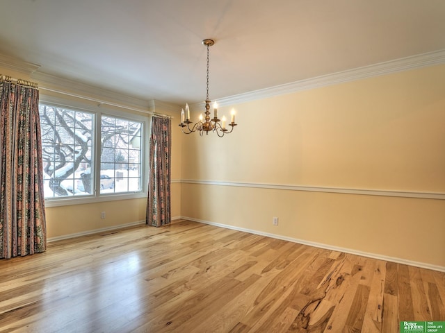 unfurnished room featuring a notable chandelier, light wood finished floors, visible vents, ornamental molding, and baseboards