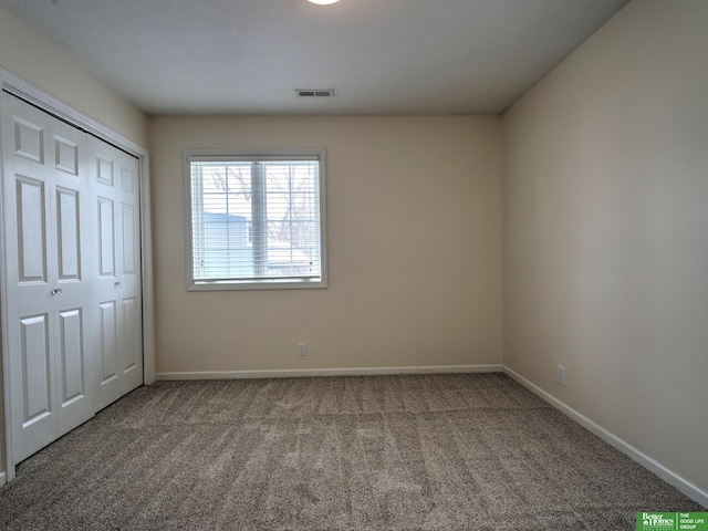 unfurnished bedroom featuring a closet, carpet, visible vents, and baseboards