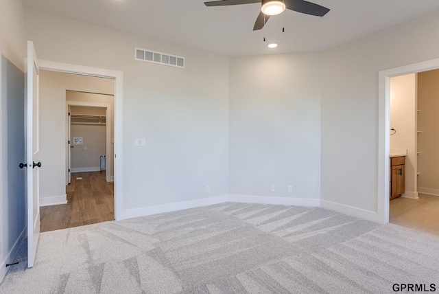unfurnished bedroom with light colored carpet and ensuite bath