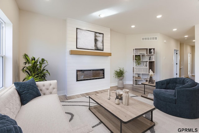 living room featuring plenty of natural light, a fireplace, and light hardwood / wood-style floors