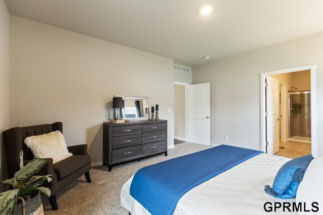 bedroom featuring light carpet and ensuite bath