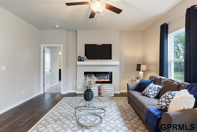 living room with dark wood-type flooring and ceiling fan