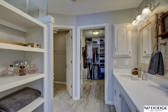 bathroom featuring hardwood / wood-style flooring, vanity, and a textured ceiling