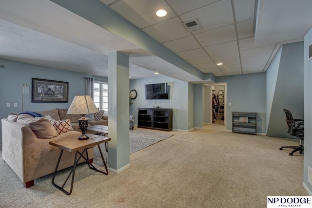 carpeted living room with a paneled ceiling