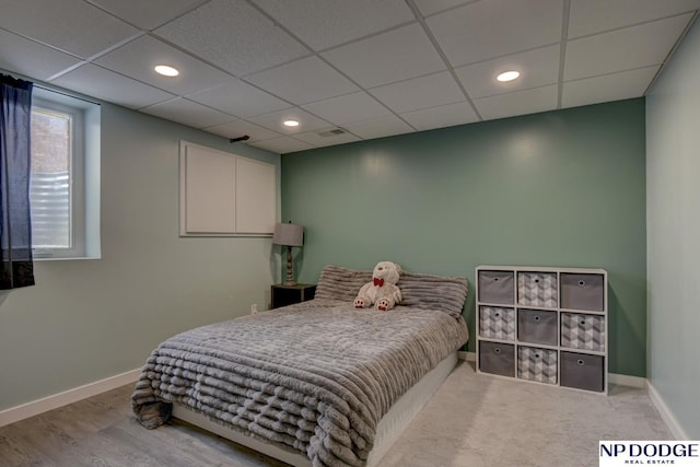 bedroom with wood-type flooring and a drop ceiling