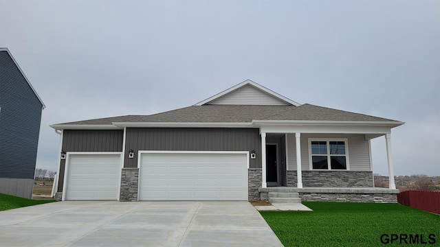 view of front facade featuring a garage, a front lawn, and a porch