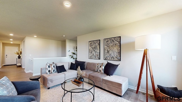 living room with hardwood / wood-style floors and a textured ceiling