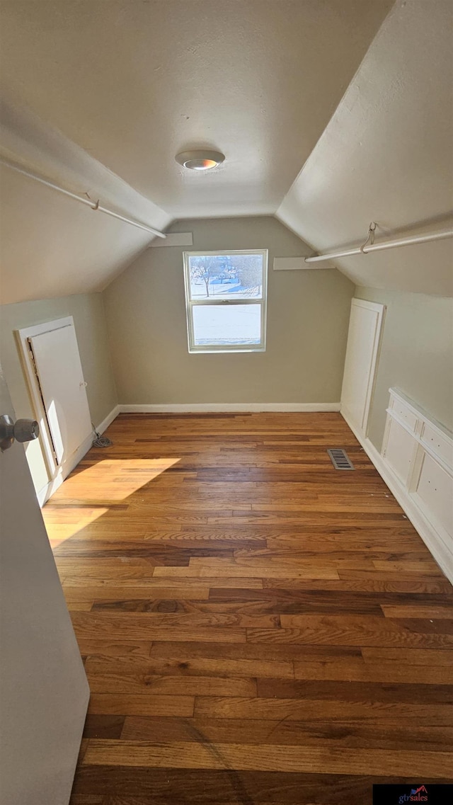 bonus room with lofted ceiling and hardwood / wood-style floors